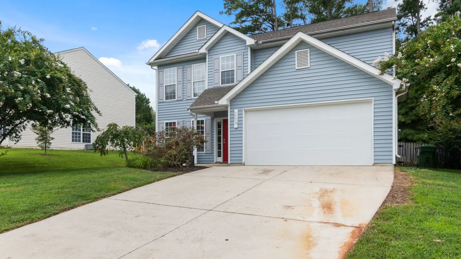 A suburban house with a clear driveway leading up to the garage